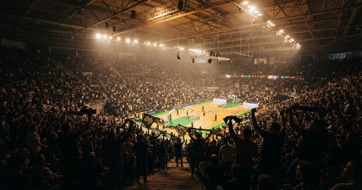 A packed sports hall under floodlights photographed from a long way off