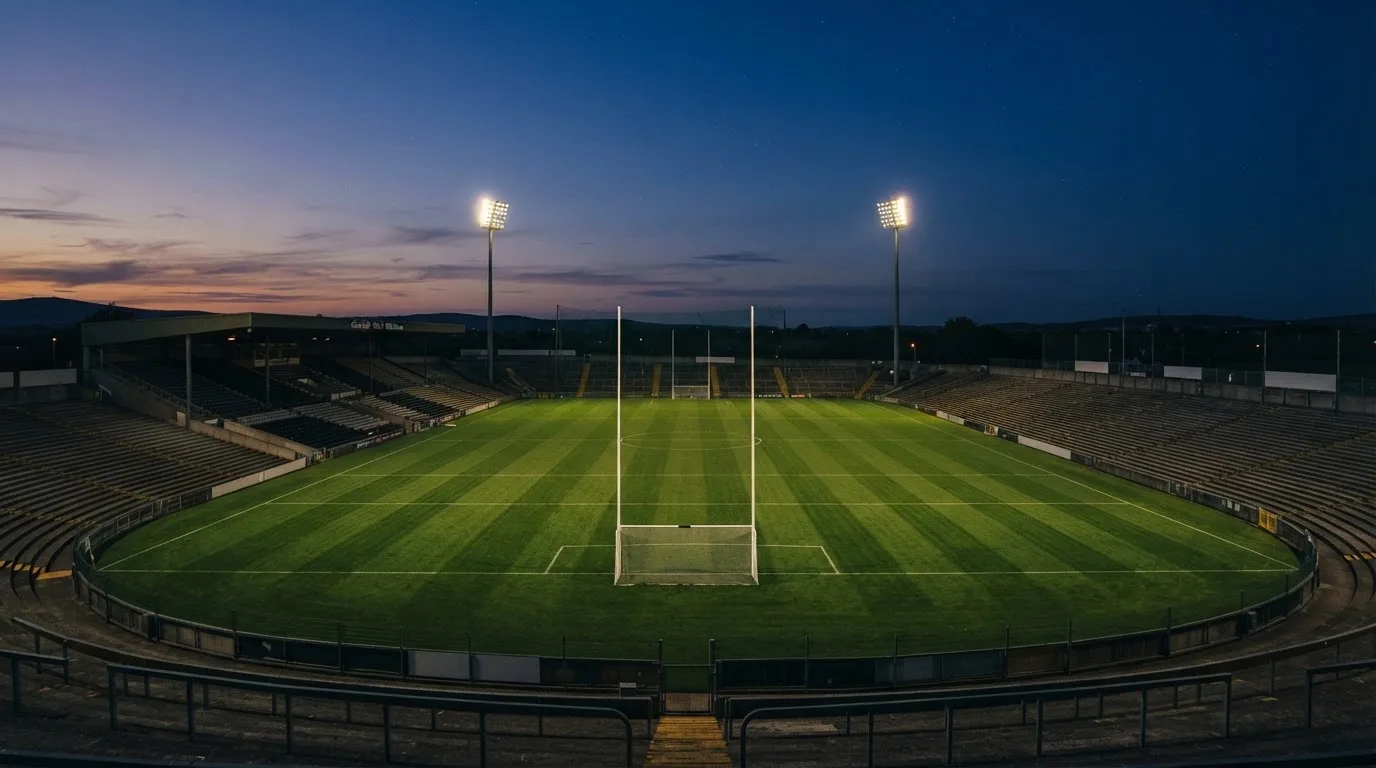An empty football stadium with floodlight masts at dusk