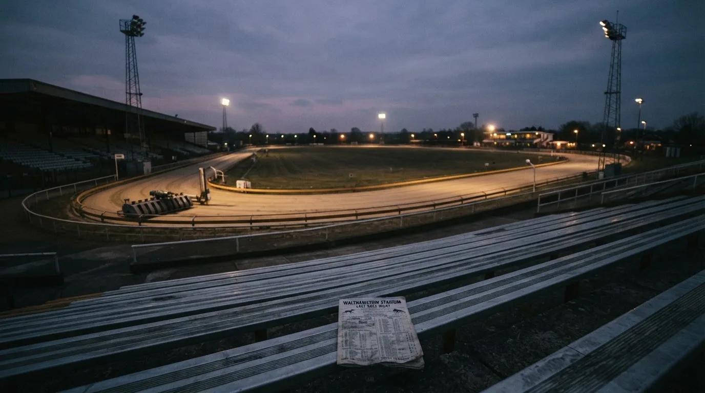 An empty football stadium with floodlight masts at dusk