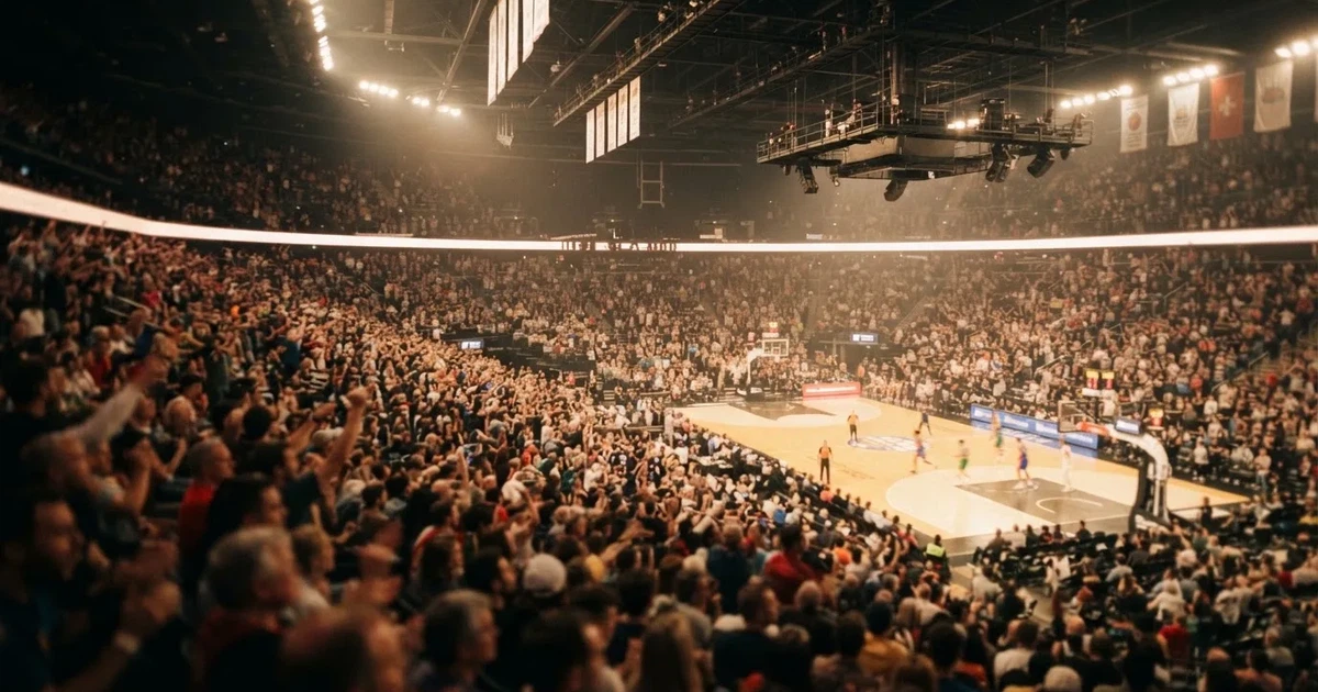A packed sports hall under floodlights photographed from a long way off