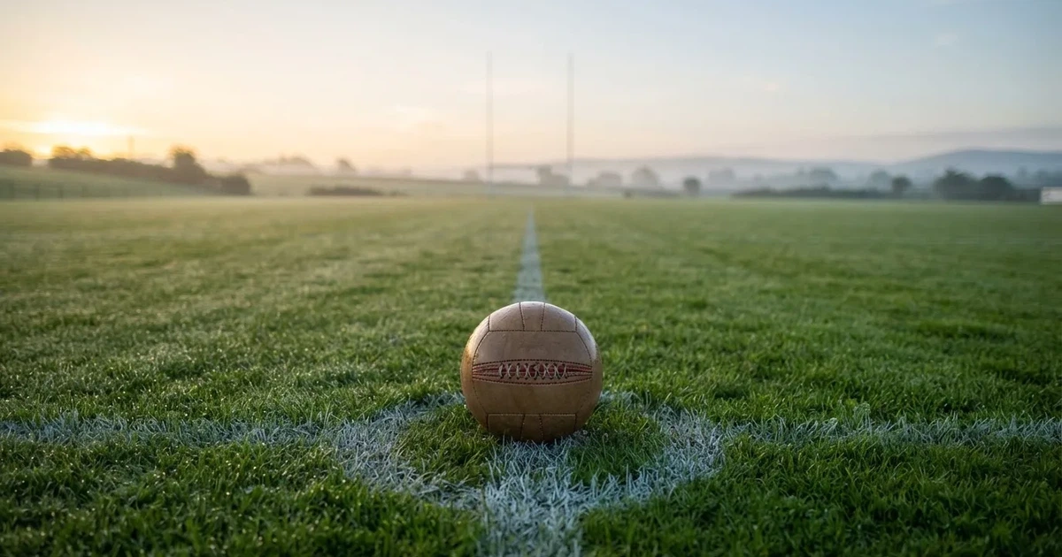 A ball on the centre spot of a grass pitch in morning light